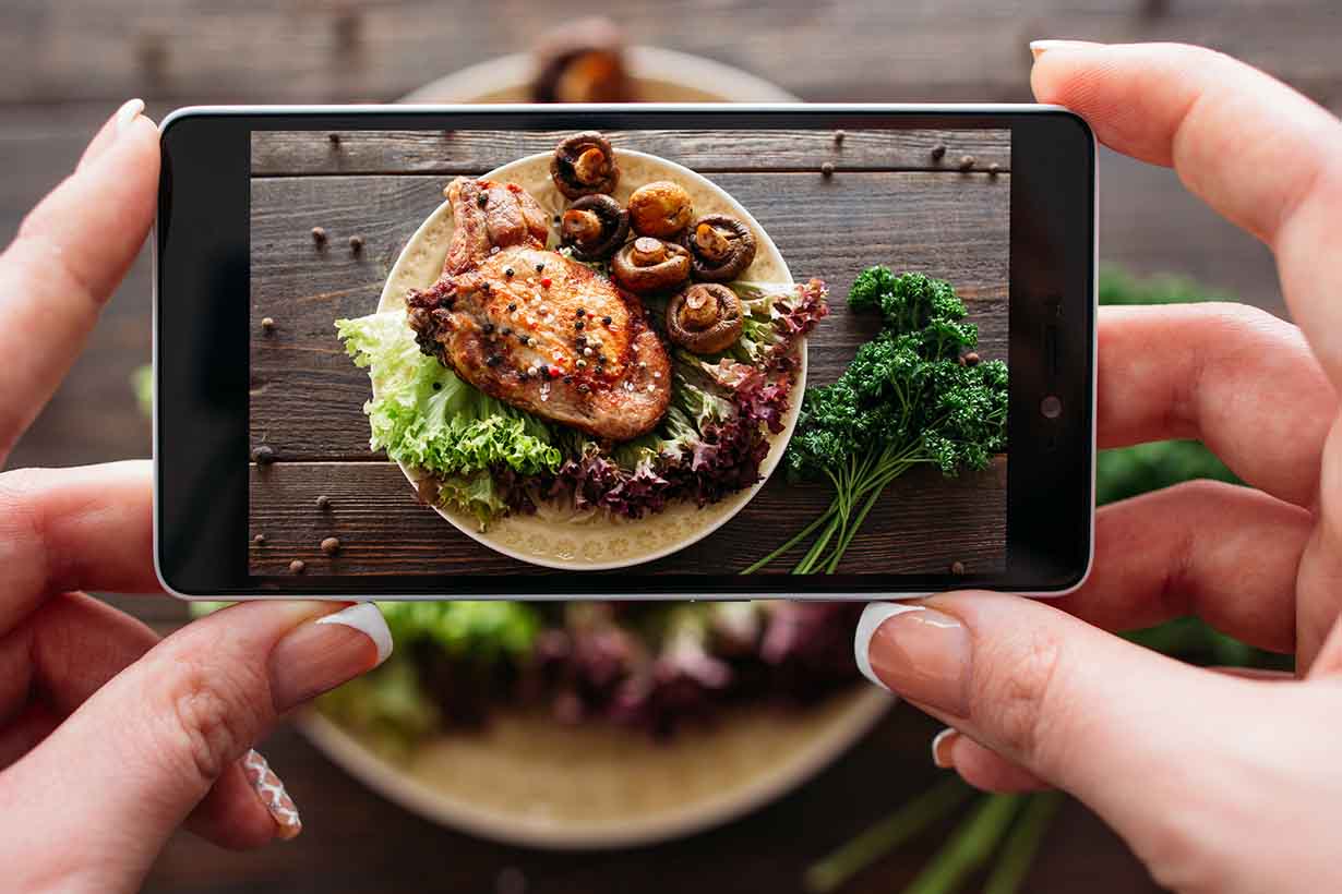 Taking a Photo of a Pork Dish With a Smart Phone.