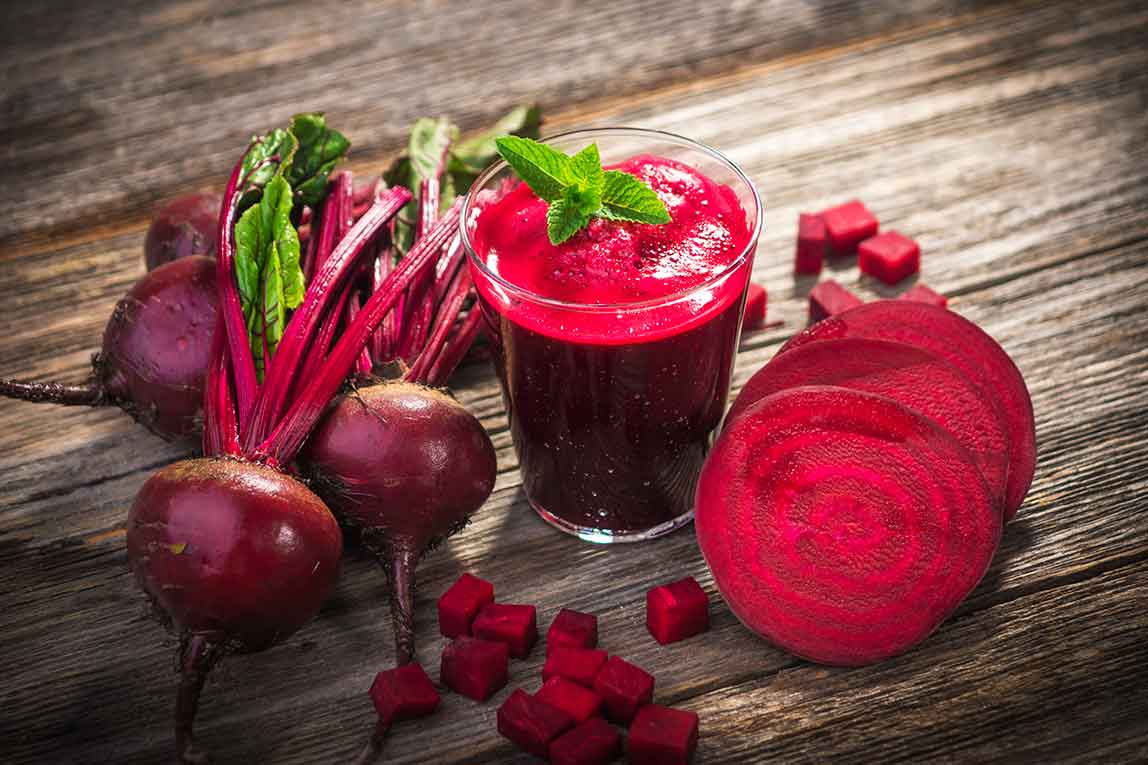 Beets and a Glass of Beet Juice On Wooden Table.