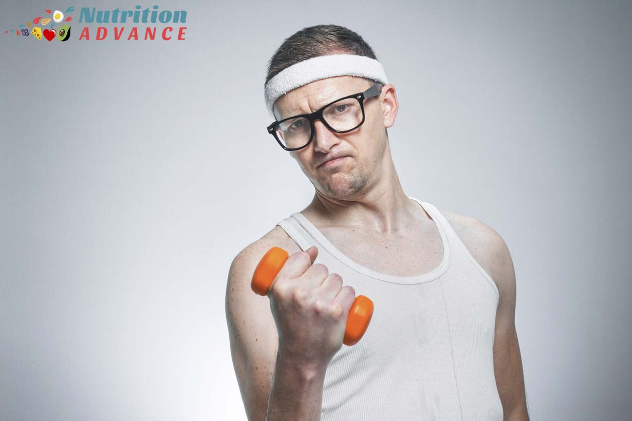A slim-looking man dressed in workout clothes holding a dumbbell.