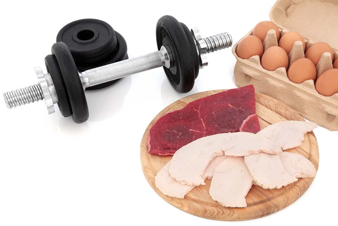 A Dumbbell Next To Eggs and Various Meat Options.