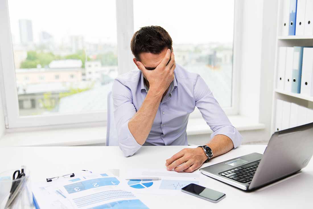 A Stressed Office Worker Holding His Head.