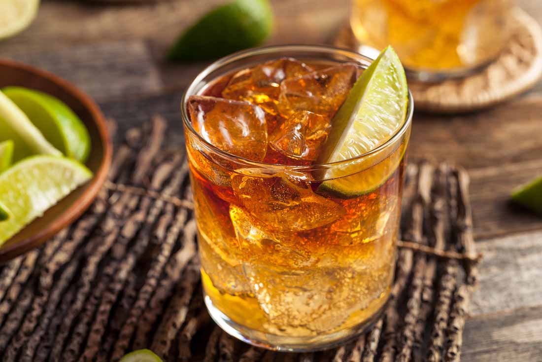 A Glass of Rum With Ice Cubes and a Slice of Lime.