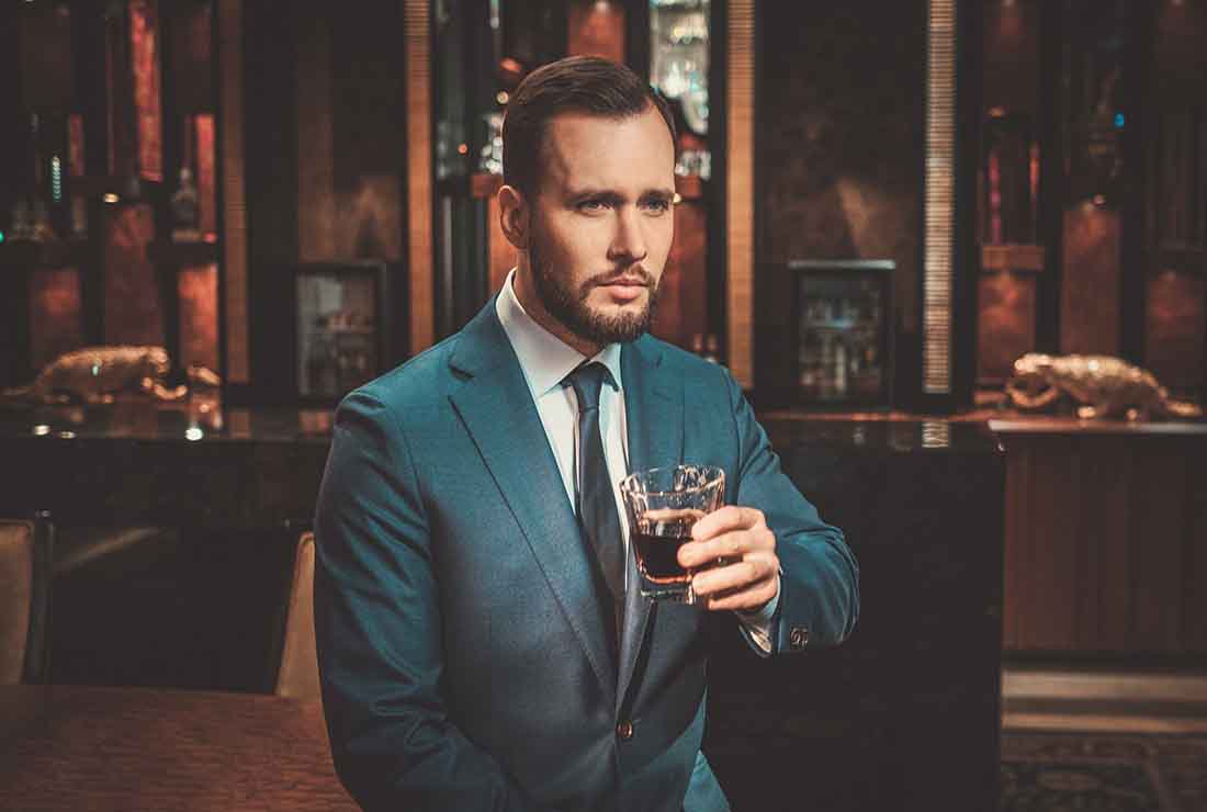 A Businessman in a Bar Drinking a Glass of Whisky.