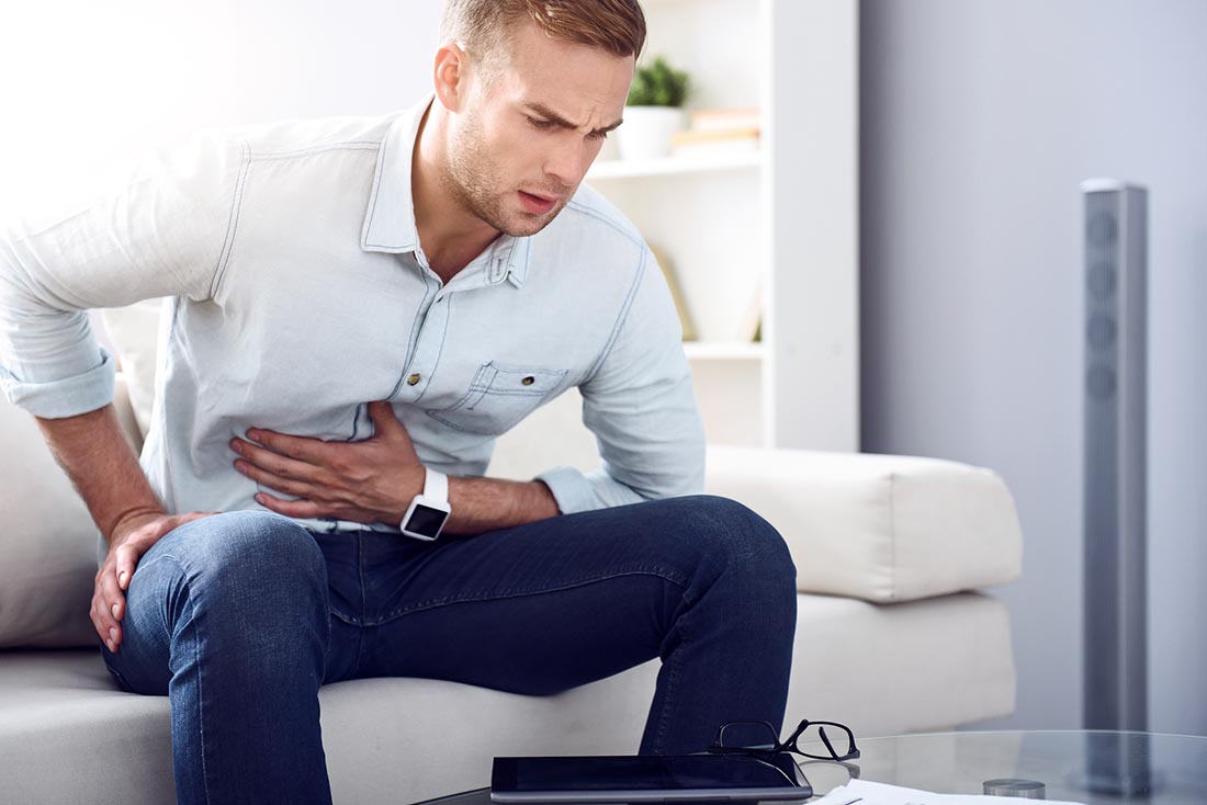 A Man Suffering From a Stomachache - Holding Stomach With Left Hand.