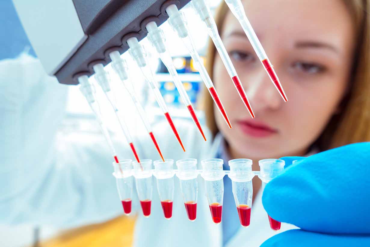 A Female Scientist Taking Samples in Test Tubes.