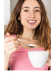 A Woman Putting Swerve Sweetener In Her Coffee.