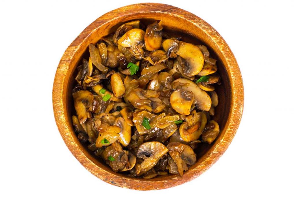 A picture of sauteed mushrooms in a wooden bowl.