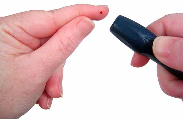 A Man Checking Blood Sugar Levels With a Glucometer.