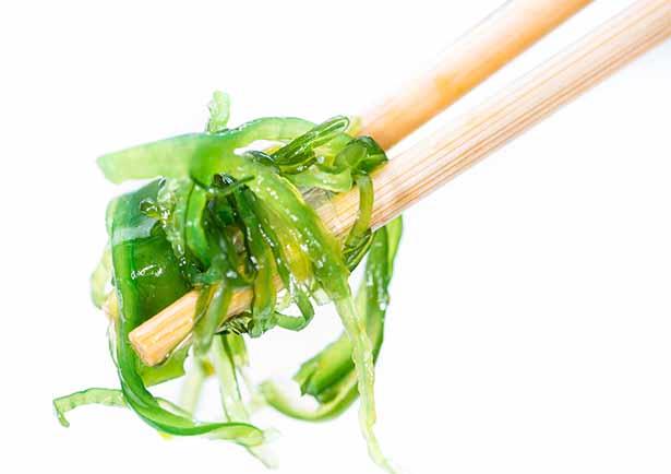 Someone Holding Kelp With Two Chopsticks.