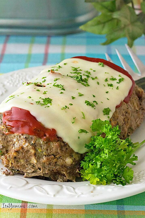 Picture of a meatloaf covered in tomato and melted cheese.