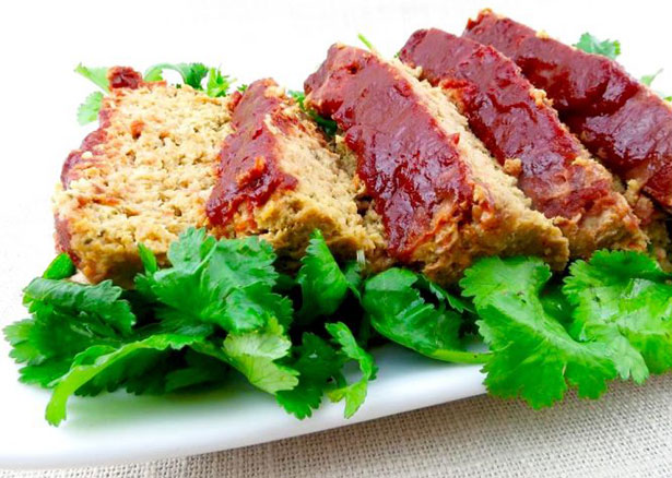 Picture of a paleo meatloaf on a bed of lettuce.