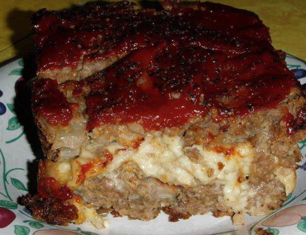 Picture of a meatloaf covered in pepper jack cheese and tomato.