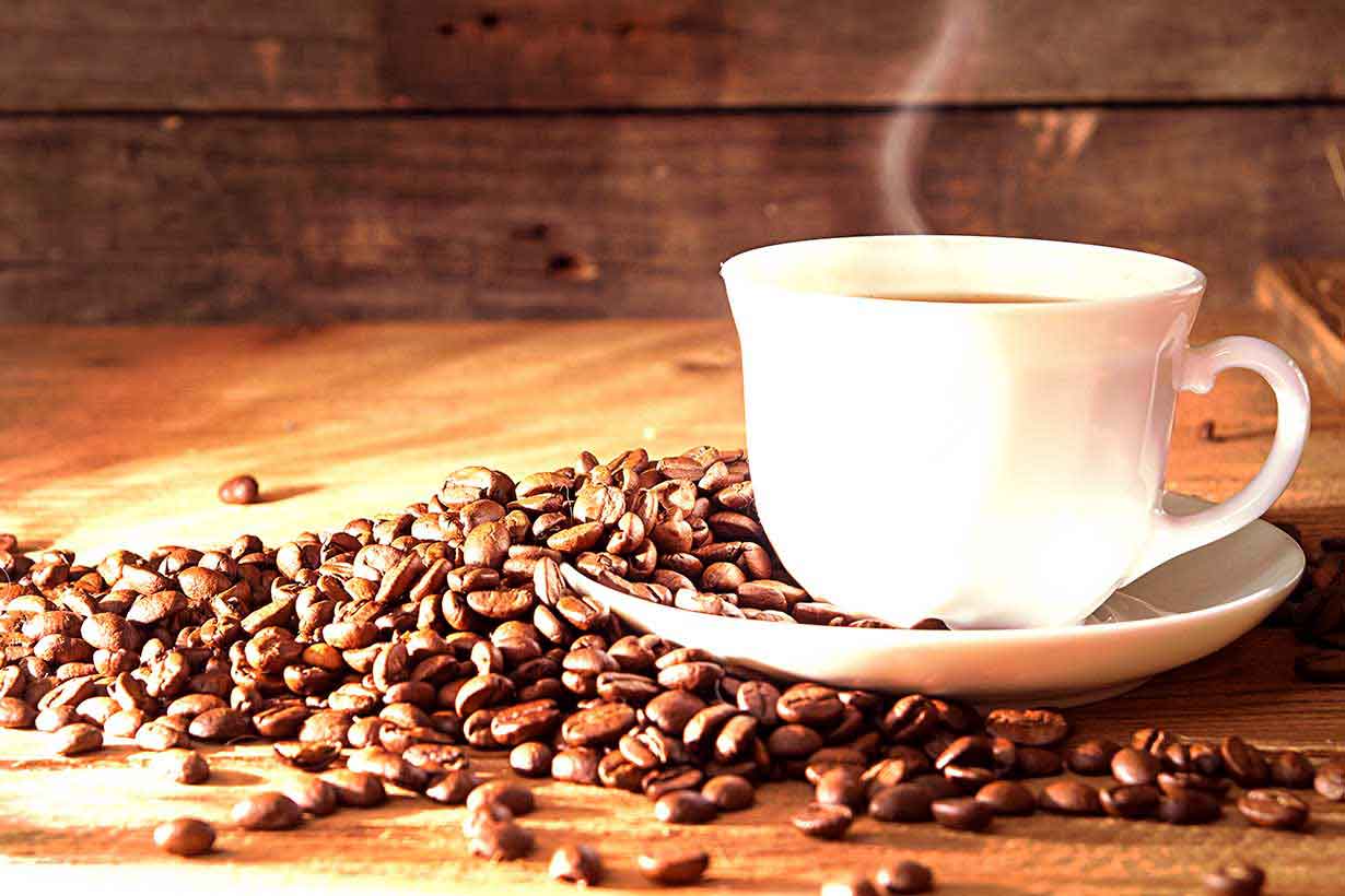 Picture Showing Coffee and Coffee Beans on a Wooden Table.