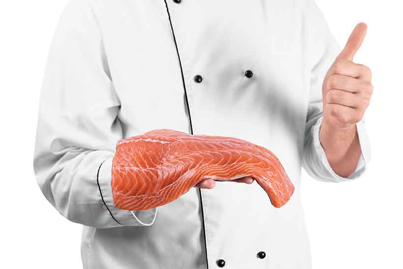 A Chef Holding a Fillet of Salmon.