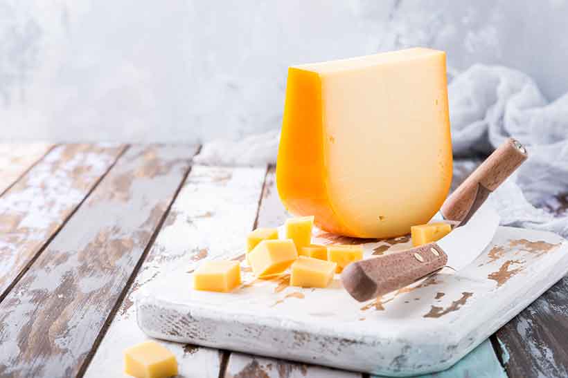 Dutch Gouda Cheese On a Cheese Board With Knife.