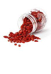 Picture of Goji Berries Spilling Out of a Glass Container.