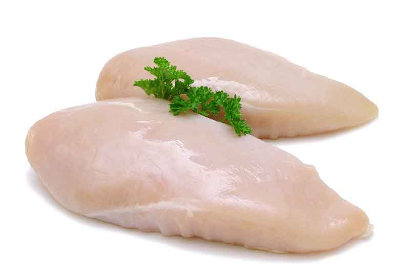 Two Raw Chicken Breasts With a Sprig of Parsley.