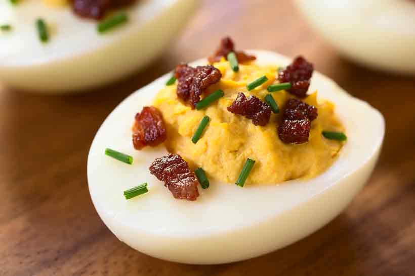 Devilled Eggs With Bacon Pieces and Chopped Chives.