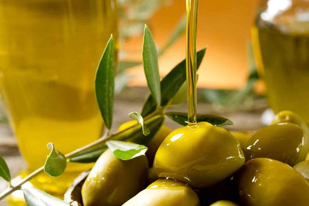 Picture of Green Olives Being Covered With Extra Virgin Olive Oil.