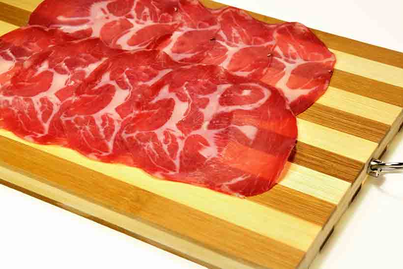 Rebanadas de Coppa (Carne Curada) En una Tabla de Madera.