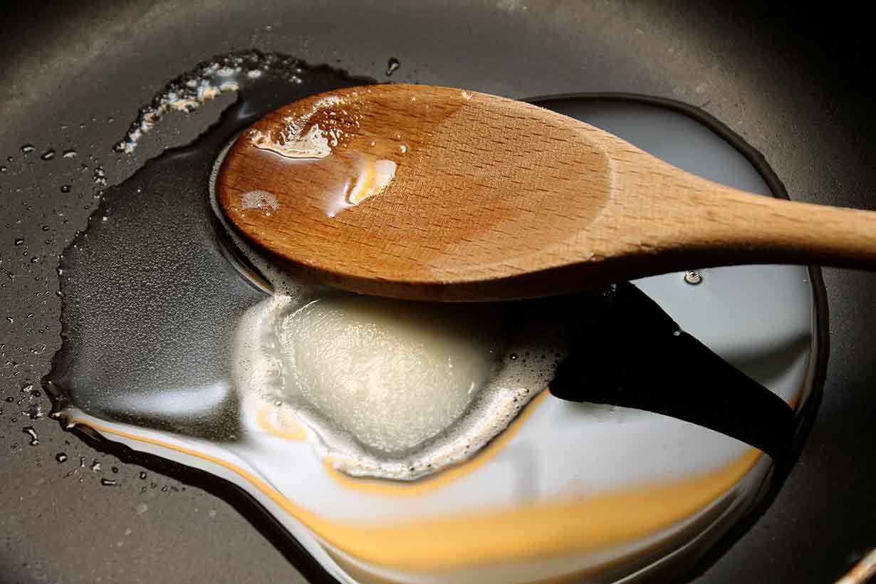 Animal Fat - Lard - Melting In a Pan After Being Added With a Spoon.