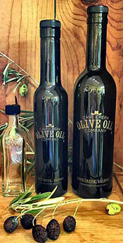 A Dark Black Bottle of Cave Creek's Ultra Premium Extra Virgin Olive Oil.