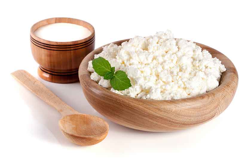 A Wooden Bowl Containing Cottage Cheese - a Fresh Dairy Product.