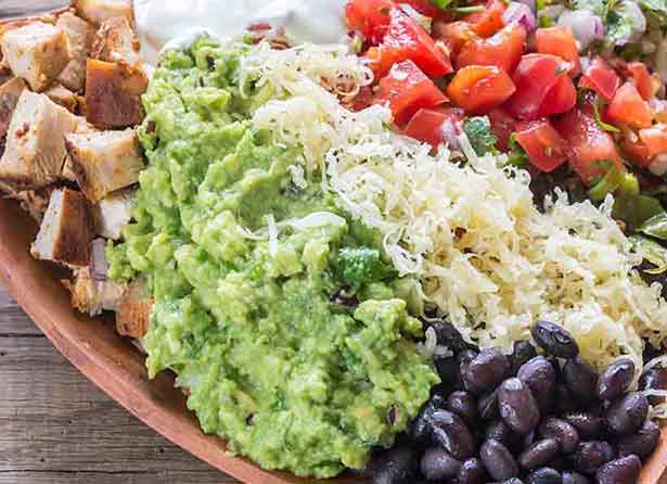 Chipotle Burrito Bowl Featuring Guacamole, Cheese, Tomatoes and Olives.