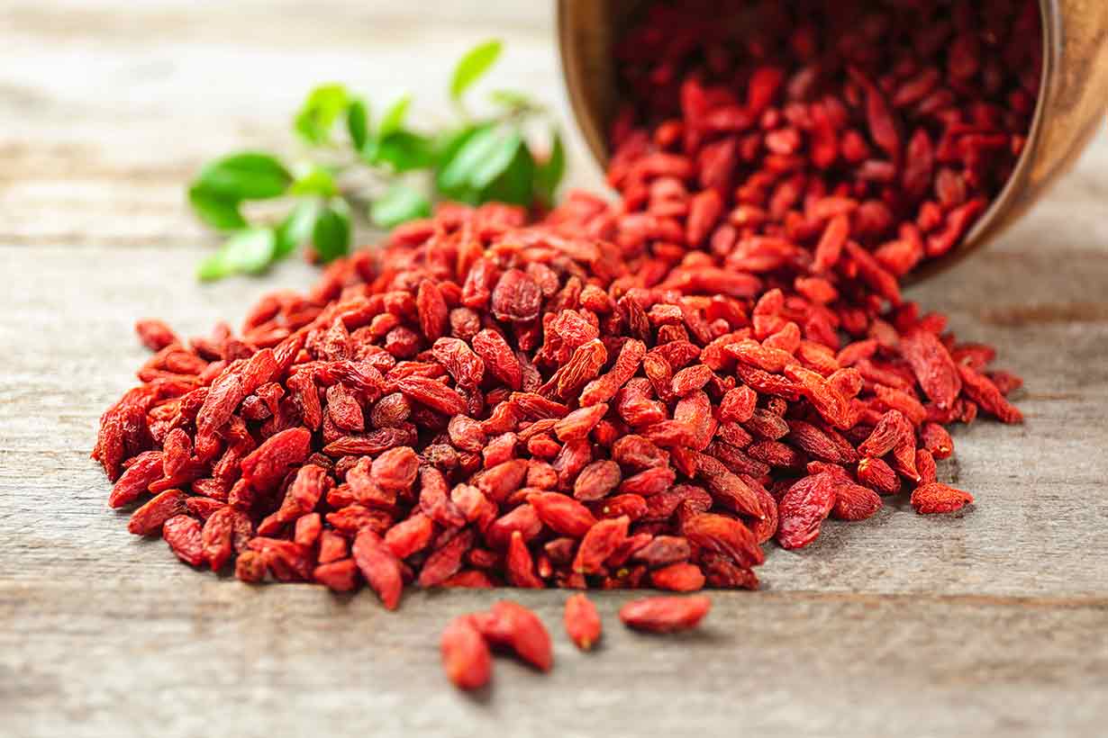 A Large Container With Goji Berries Spilling Out.