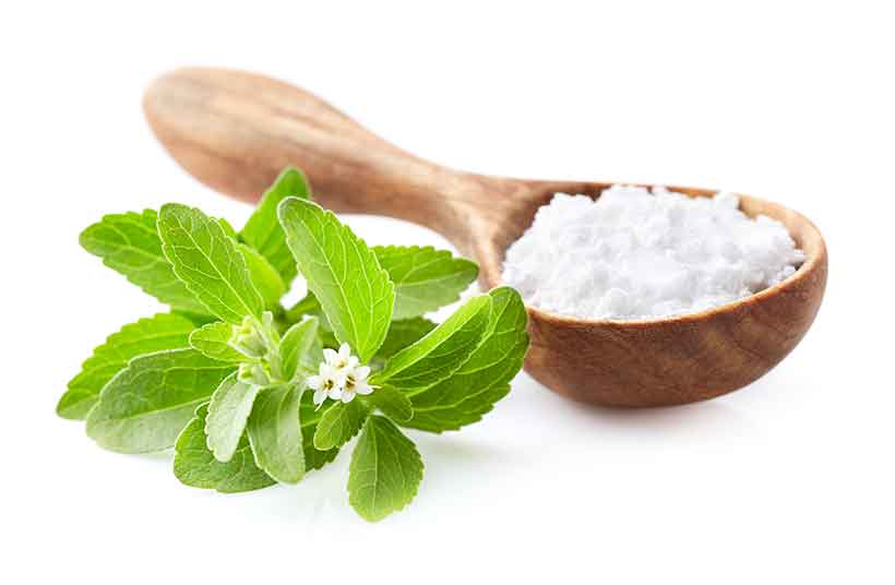 Stevia Leaves Next To the Powdered Sweetener.