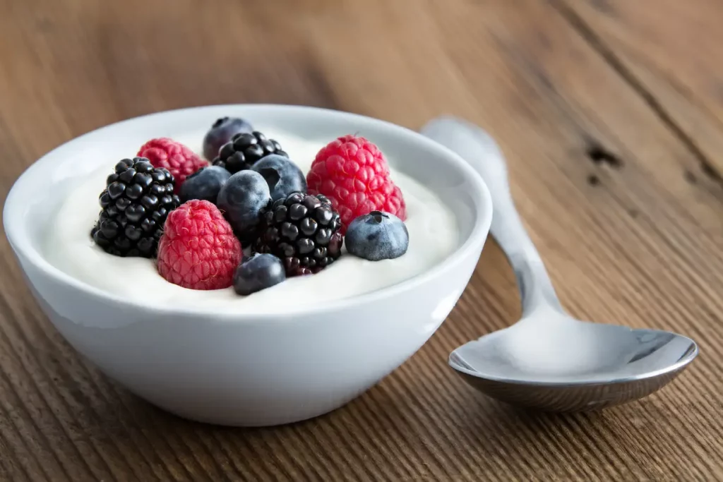 A bowl of yogurt paired with mixed berries.