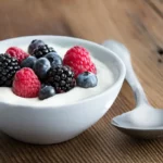 A bowl of yogurt paired with mixed berries.