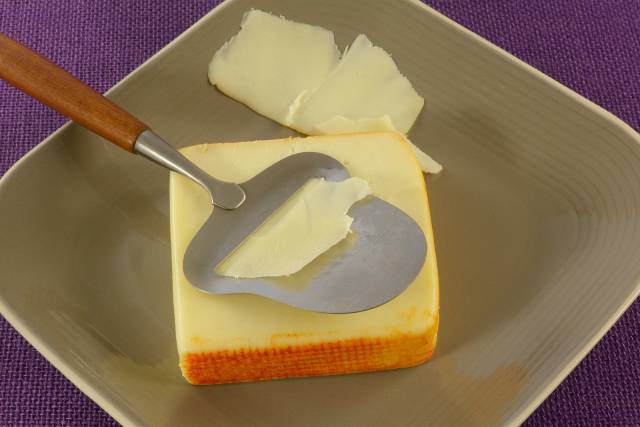 A Large Piece of Muenster Cheese On a Plate.