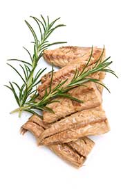 Several Cooked Mackerel Fillets With a Sprig of Rosemary.