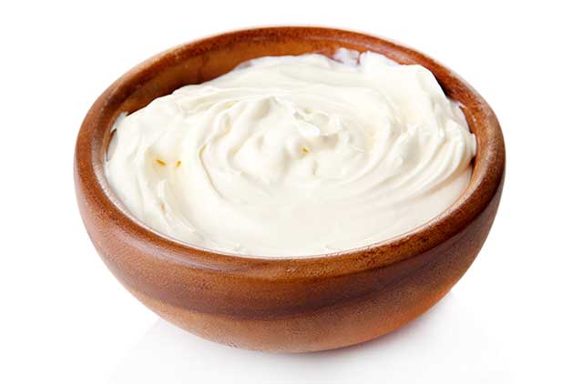 Thick Sour Cream In a Wooden Bowl.