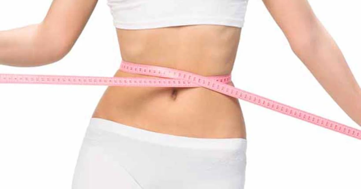 A woman with a tape measure around her waist - weight loss theme.