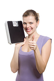 A Woman Happy After Losing Weight, Holding a Scale.