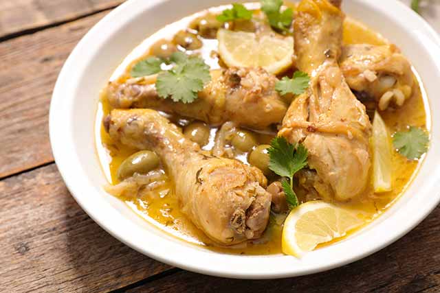 A Bowl Containing Chicken Drumsticks In a Lemon Butter Sauce.