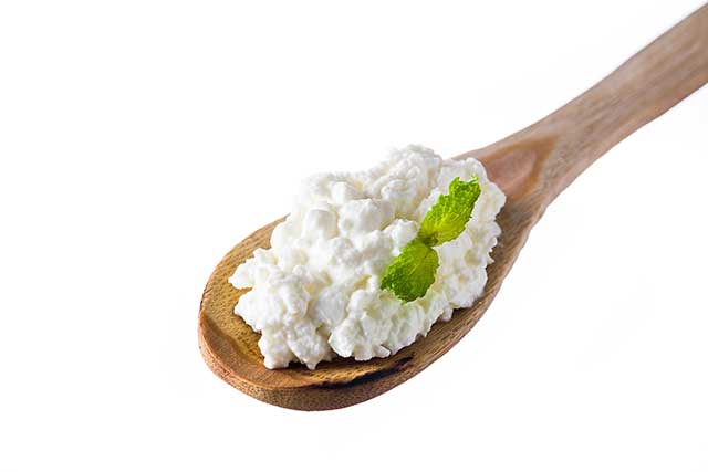 Cottage Cheese On a Wooden Spoon.