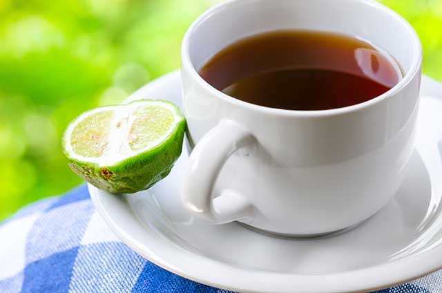 Cup of Earl Grey Black Tea Next To Half a Bergamot Orange.