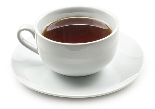 A Hot Cup of Black Tea In a White Cup With White Saucer.