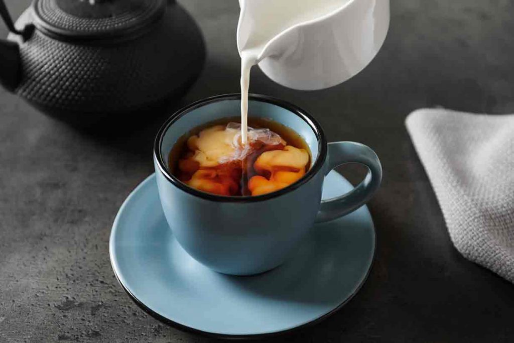 Adding Milk To a Cup of Black Tea.