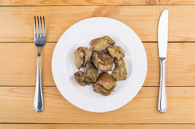 Pieces of Pan-Fried Chicken Liver On a Plate With Knife and Fork.