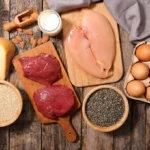Numerous protein-rich foods on a wooden table.