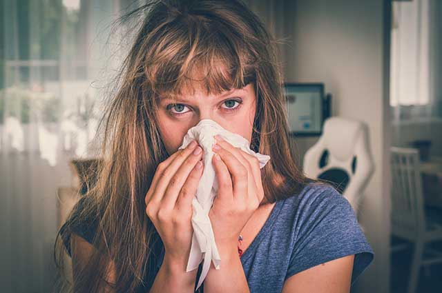 Sick Woman With Flu Using a Handkerchief.