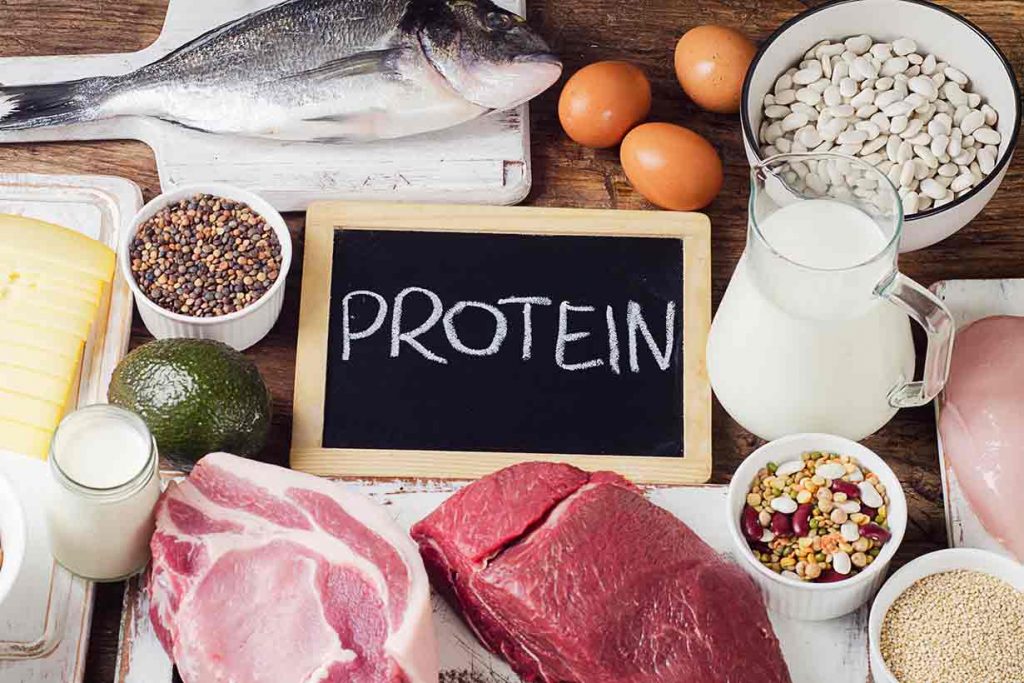 High protein foods on a table - meat, eggs, legumes, etc.