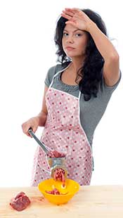 A Woman Grinding Meat In a Meat Grinder.