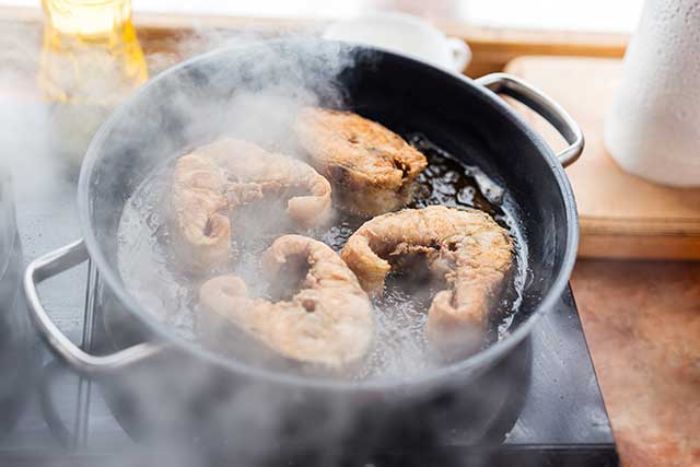 Frying Pan Smoking From High Heat Cooking With Sesame Oil.