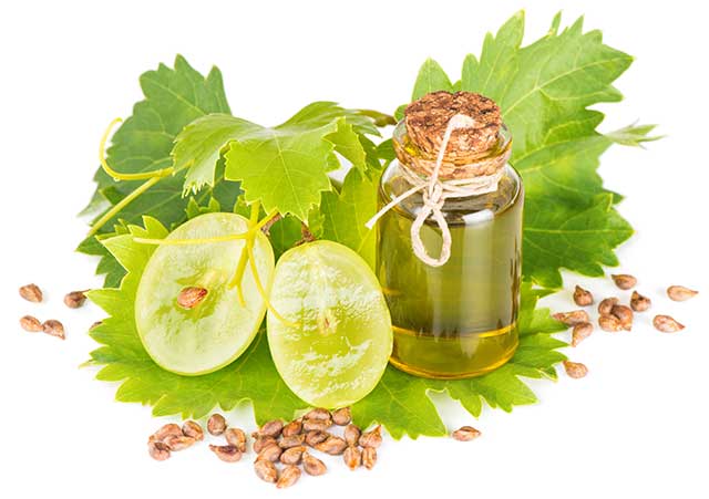 Grapeseed Oil In a Glass Bottle Next To Fresh Grapes.