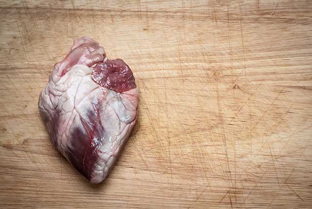 A Raw Lamb Heart On a Wooden Counter.